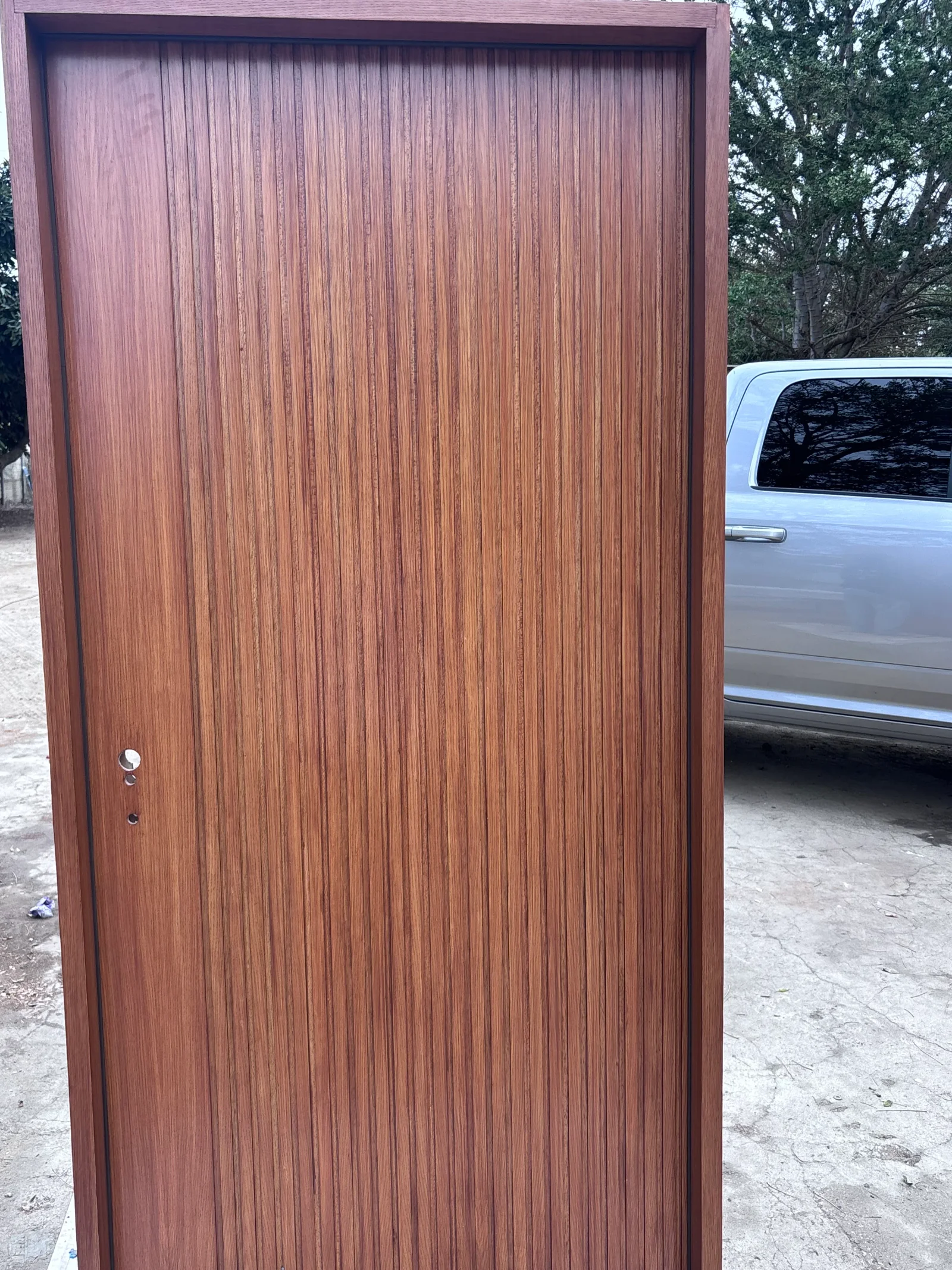 Mahogany-stained vertical wood plank garage door with polished hardware