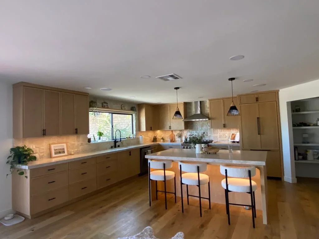 Kitchen with painted walls, ceiling, and trim; wood cabinetry and island with seating