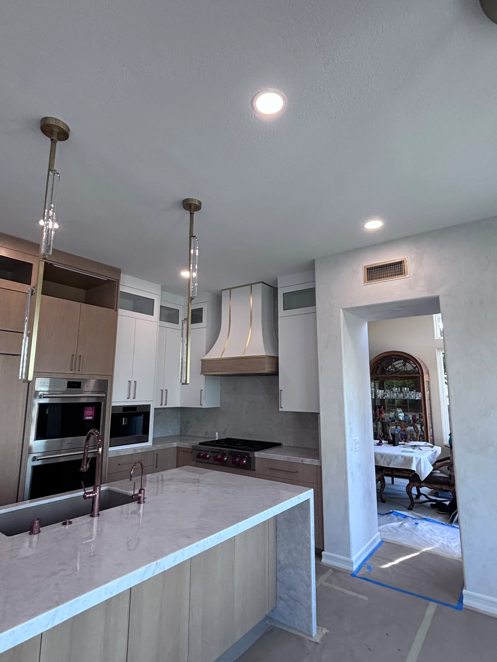 White painted kitchen with custom cabinetry, stainless steel appliances, and recessed lighting